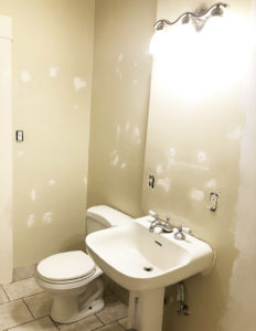 Photo of bathroom with holes in walls patched.