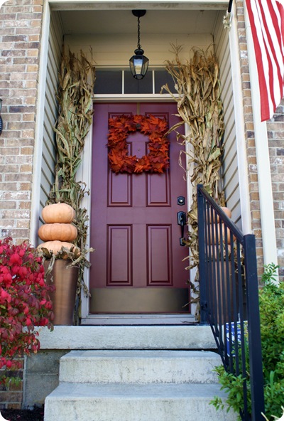 Cornstalks, a wreath, and some pumpkins are all you need to create this front door. Found on Thrifty Decor Chick.