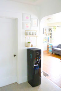 Primo water station in kitchen with living room in background.